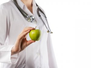 Female,Doctor's,Hand,Holding,Green,Apple,Isolated,On,White,Background.